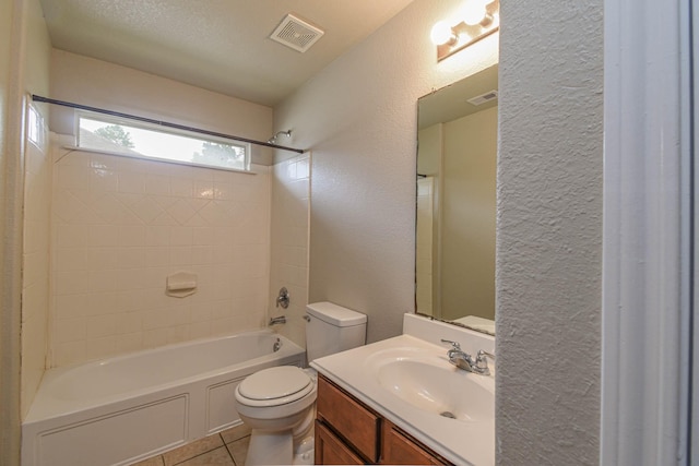 full bathroom featuring vanity, tile patterned flooring, tiled shower / bath combo, toilet, and a textured ceiling