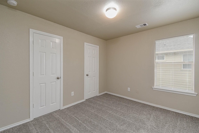 unfurnished bedroom with carpet flooring and a textured ceiling