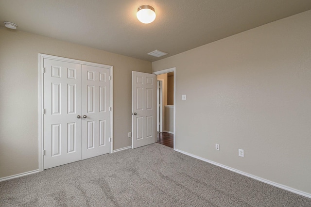 unfurnished bedroom featuring carpet flooring and a closet