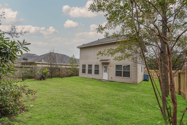 rear view of house featuring cooling unit and a yard