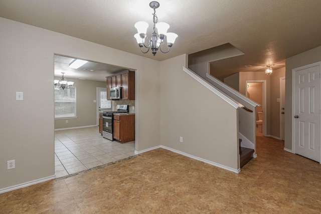 interior space featuring light tile patterned floors, a textured ceiling, and an inviting chandelier