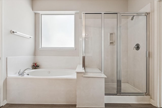 bathroom featuring shower with separate bathtub and hardwood / wood-style floors