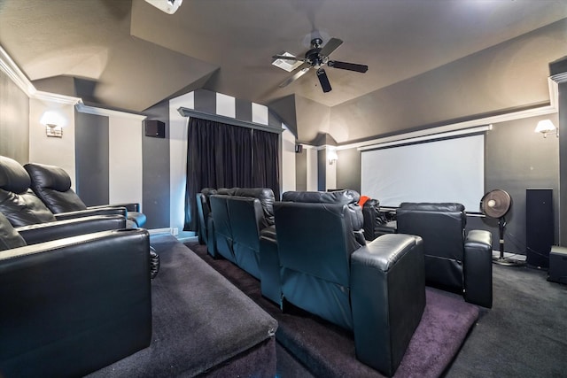 home theater room featuring dark colored carpet, ceiling fan, ornamental molding, and vaulted ceiling