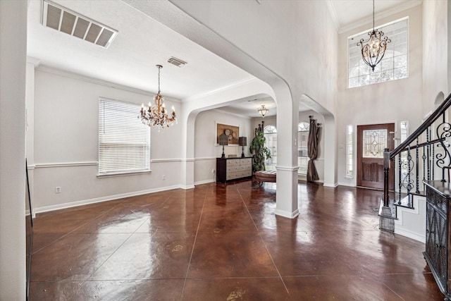 foyer entrance with an inviting chandelier and ornamental molding