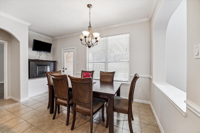 dining space featuring a notable chandelier, plenty of natural light, light tile patterned flooring, and ornamental molding