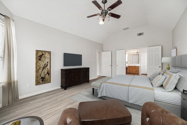 bedroom featuring ensuite bath, ceiling fan, lofted ceiling, and light wood-type flooring