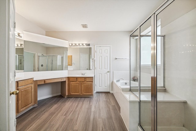 bathroom with hardwood / wood-style floors, vanity, and independent shower and bath