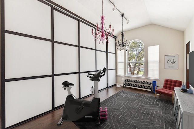 exercise area featuring a notable chandelier, dark hardwood / wood-style flooring, and lofted ceiling