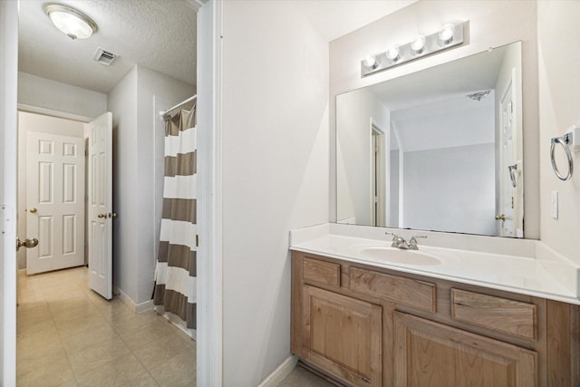 bathroom with vanity, curtained shower, and a textured ceiling