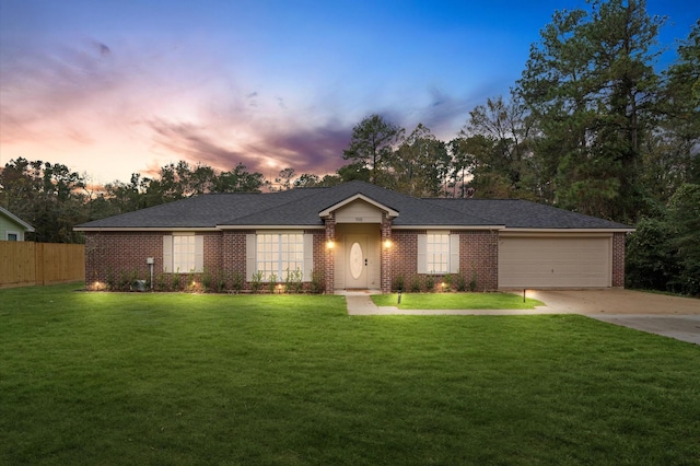 single story home featuring a garage and a yard