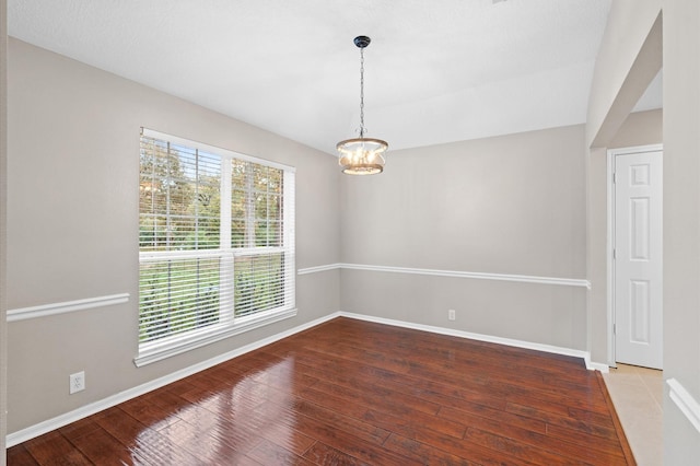 unfurnished room featuring hardwood / wood-style floors and a notable chandelier