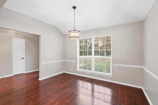 empty room featuring an inviting chandelier, dark wood-type flooring, and vaulted ceiling