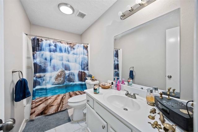 bathroom featuring vanity, a textured ceiling, and toilet