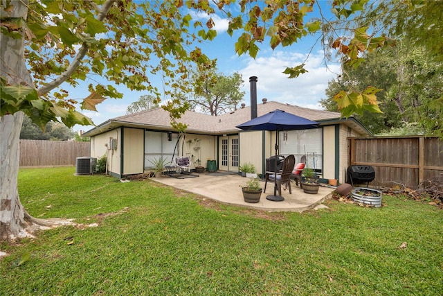 rear view of house with a patio area, central air condition unit, a yard, and french doors