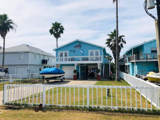 beach home featuring a front yard, central AC, and a garage