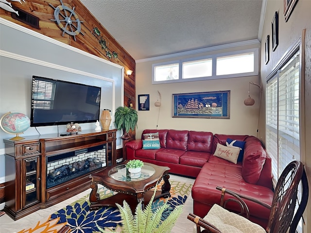 living room with a textured ceiling, wooden walls, and crown molding