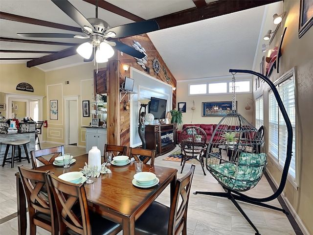 dining space featuring a textured ceiling, lofted ceiling with beams, and ceiling fan