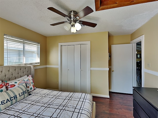 bedroom with a textured ceiling, ceiling fan, a closet, and dark hardwood / wood-style floors