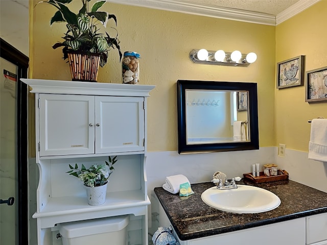 bathroom with vanity, toilet, ornamental molding, and a textured ceiling