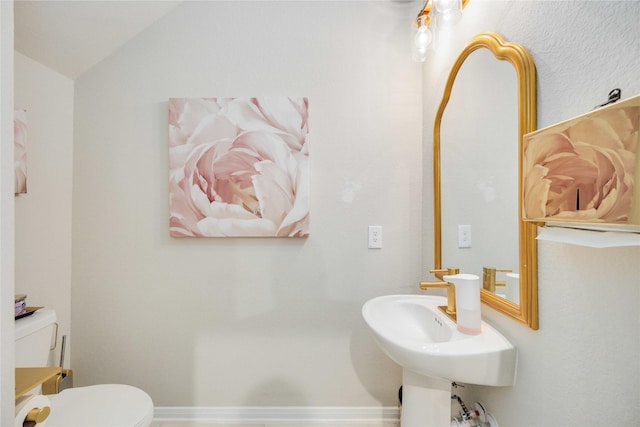 bathroom featuring vaulted ceiling and toilet