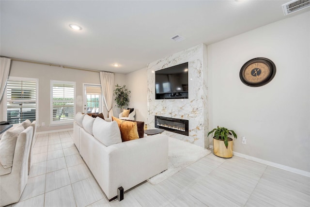 living room with light tile patterned floors and a premium fireplace