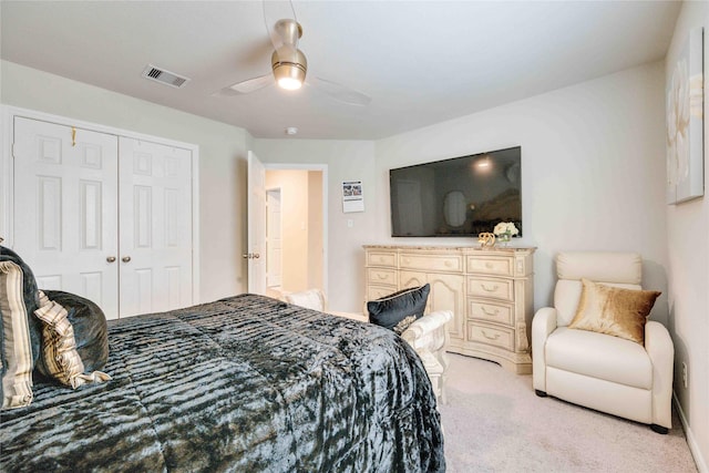 bedroom with ceiling fan, a closet, and light colored carpet