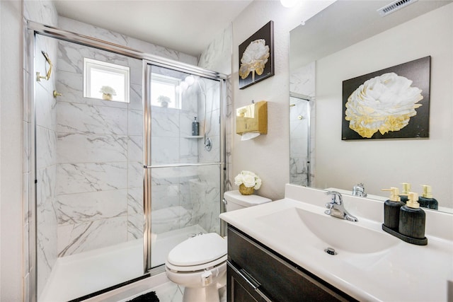 bathroom featuring a shower with door, vanity, and toilet