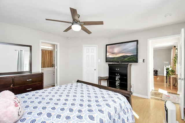 bedroom featuring connected bathroom, light hardwood / wood-style flooring, and ceiling fan