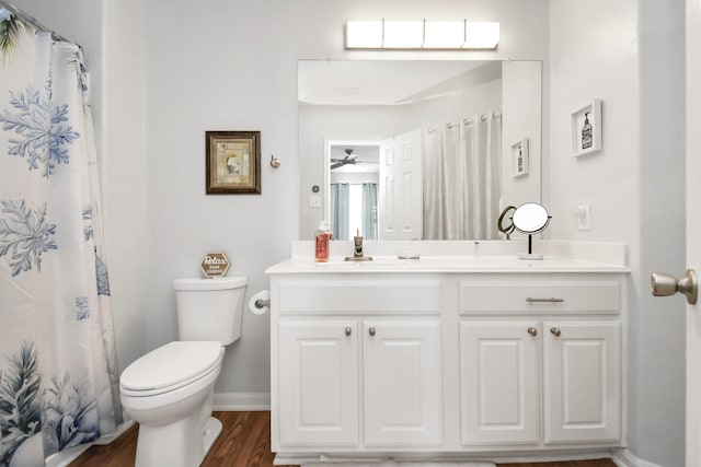 bathroom featuring walk in shower, vanity, ceiling fan, hardwood / wood-style flooring, and toilet