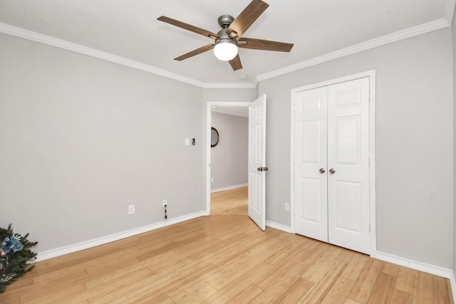 unfurnished bedroom featuring a closet, light hardwood / wood-style flooring, ceiling fan, and ornamental molding