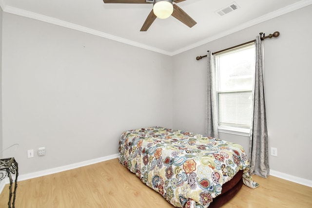 bedroom with ceiling fan, crown molding, and hardwood / wood-style flooring