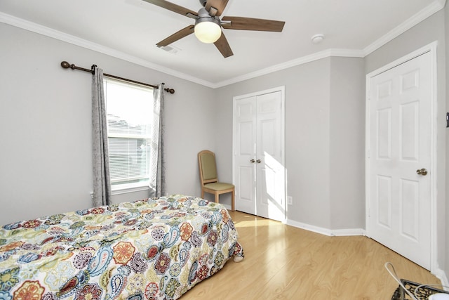 bedroom featuring hardwood / wood-style flooring, ceiling fan, ornamental molding, and a closet