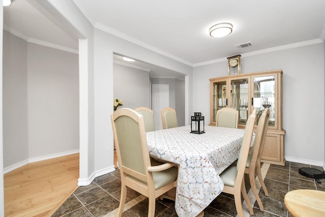 dining room featuring dark hardwood / wood-style floors and crown molding