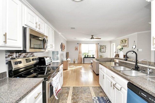 kitchen with white cabinets, appliances with stainless steel finishes, light hardwood / wood-style flooring, and sink