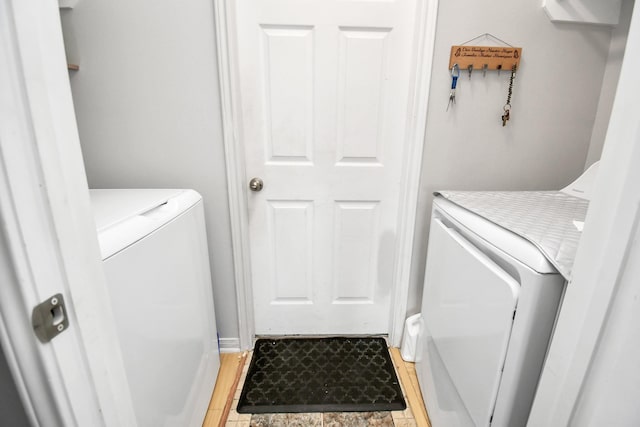 laundry room with hardwood / wood-style floors and washing machine and dryer