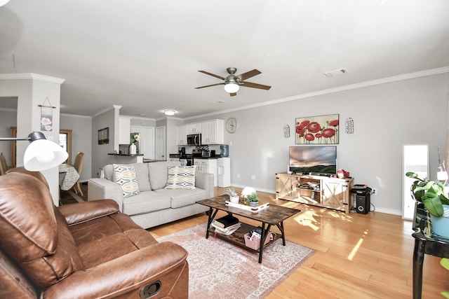 living room featuring light wood-type flooring, ceiling fan, and crown molding