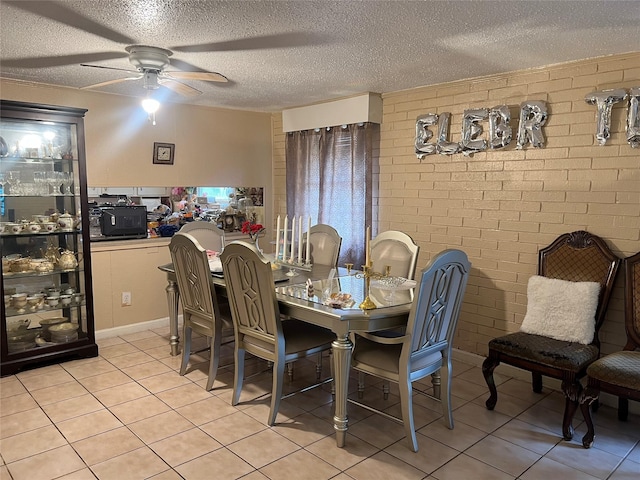 dining area featuring a textured ceiling, brick wall, and light tile patterned floors