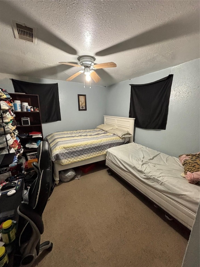 carpeted bedroom with ceiling fan and a textured ceiling