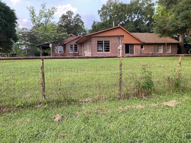 view of front of property featuring brick siding, an attached carport, and a front lawn