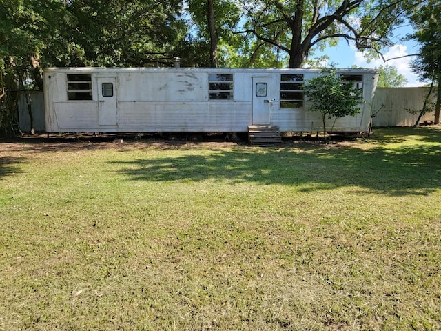 view of front facade featuring fence, a front lawn, and entry steps