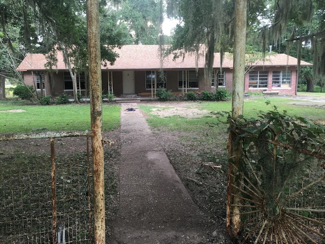 single story home with covered porch and a front yard