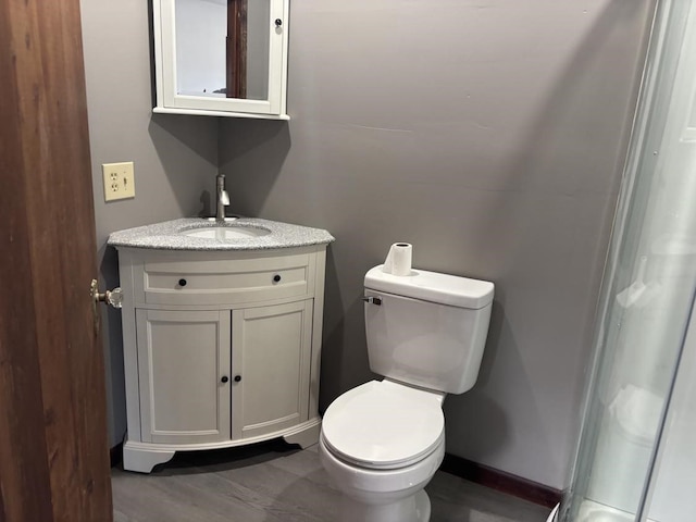 bathroom featuring vanity, toilet, and baseboards