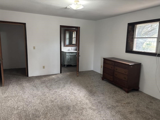 unfurnished bedroom with ensuite bath and carpet