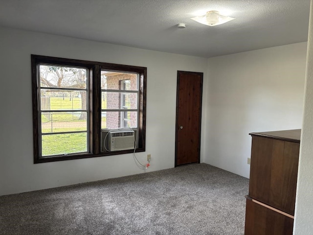 carpeted empty room with cooling unit and a textured ceiling