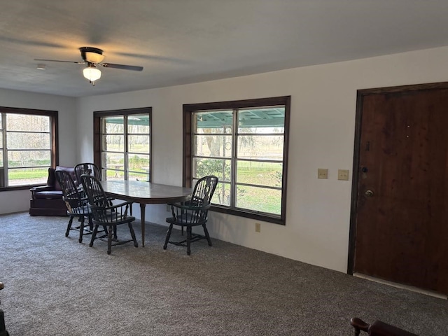 carpeted dining area with ceiling fan