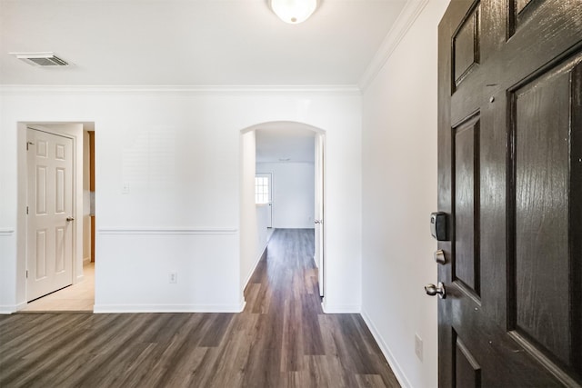 foyer entrance with ornamental molding and dark wood-type flooring