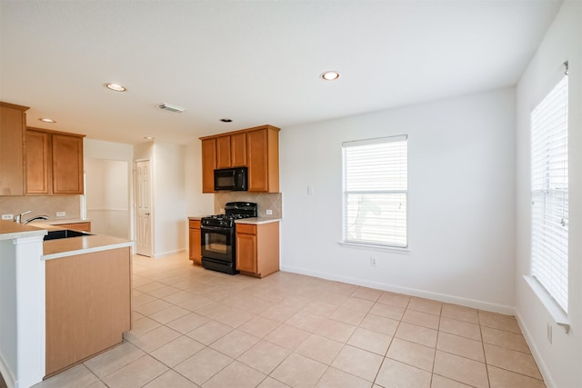 kitchen with black appliances, decorative backsplash, light tile patterned floors, and sink