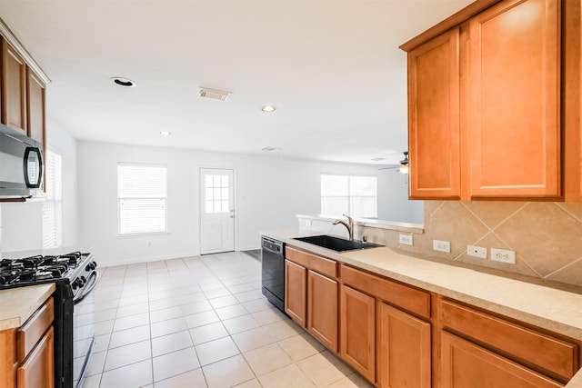 kitchen with tasteful backsplash, sink, black appliances, and plenty of natural light