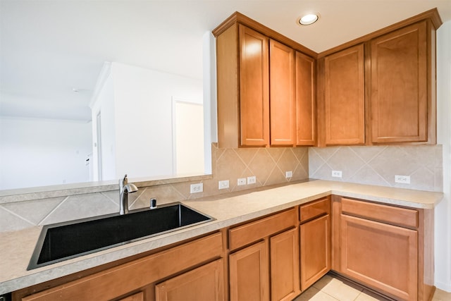 kitchen featuring light tile patterned flooring, backsplash, and sink