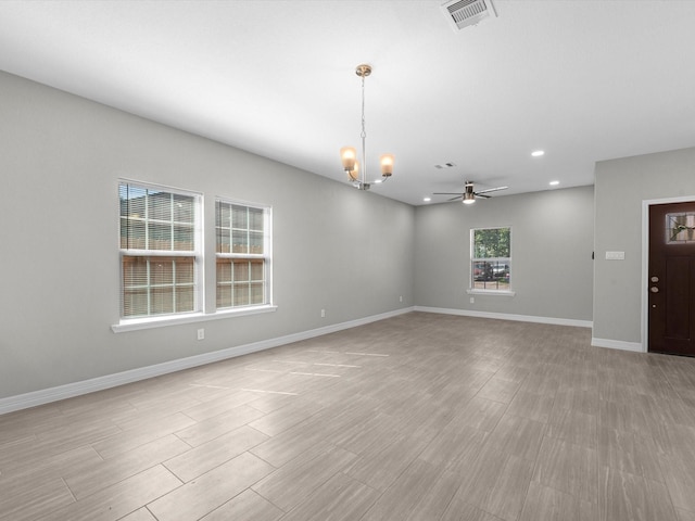 interior space featuring ceiling fan with notable chandelier